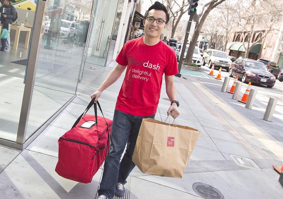 Tony Xu, founder of Doordash, carrying bags.