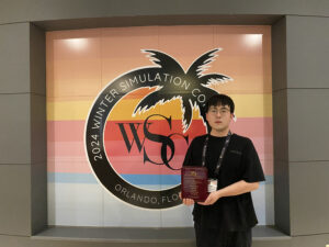 Photo of Haoting Zhang, the paper's first author, receiving the award plaque during the conference.